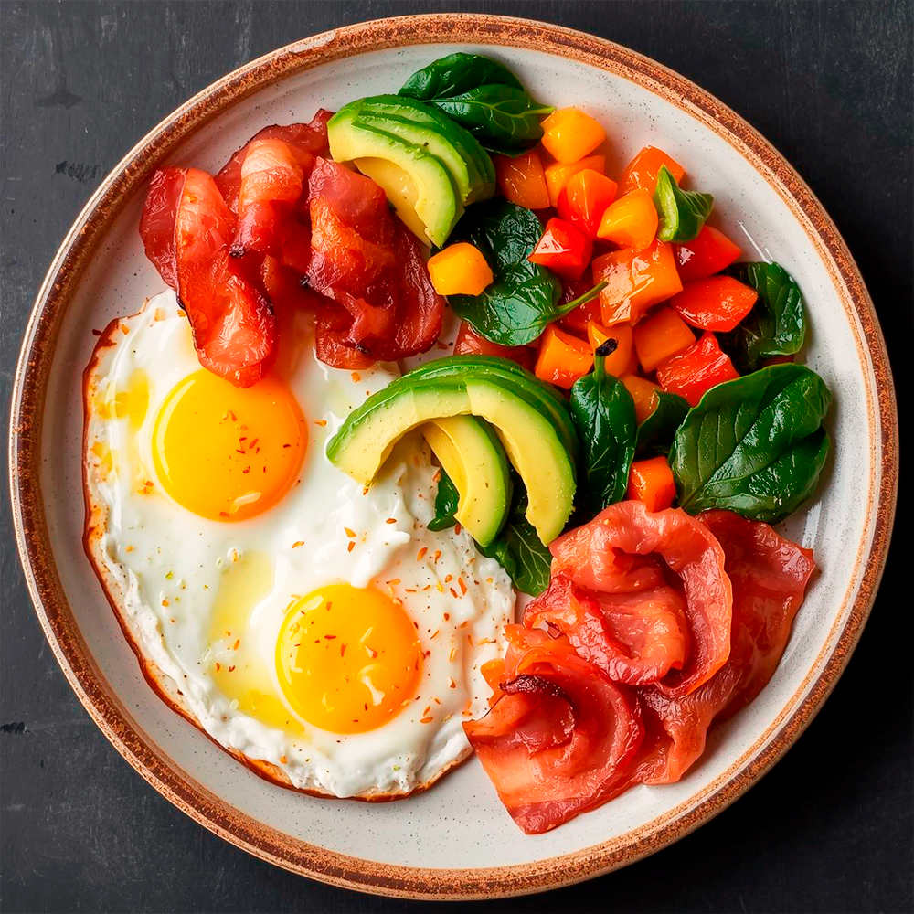 Keto diet plate with eggs, bacon, avocado, and non-starchy vegetables, showcasing significant weight loss and stable energy.