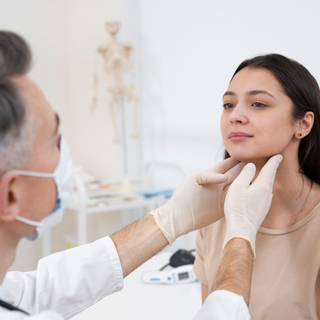 Woman in a medical consultation with a professional examining her neck, symbolizing selenium as an antioxidant that protects cells and the thyroid.