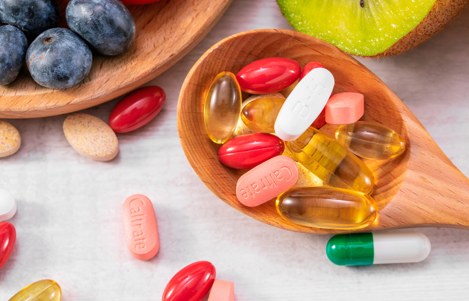 A variety of supplements and nutrient-rich fruits like kiwi and grapes, highlighting natural sources of vitamins and minerals for health